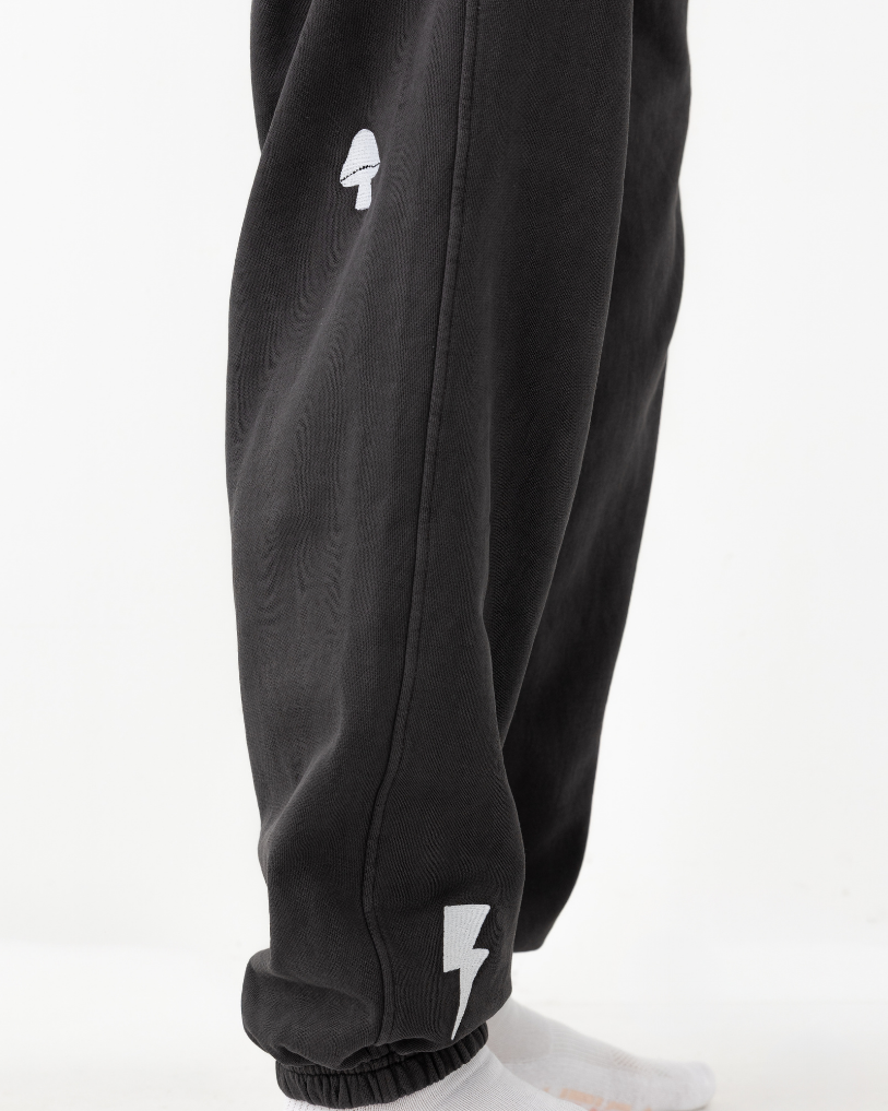 Black sweatpants with a white logo on a white background